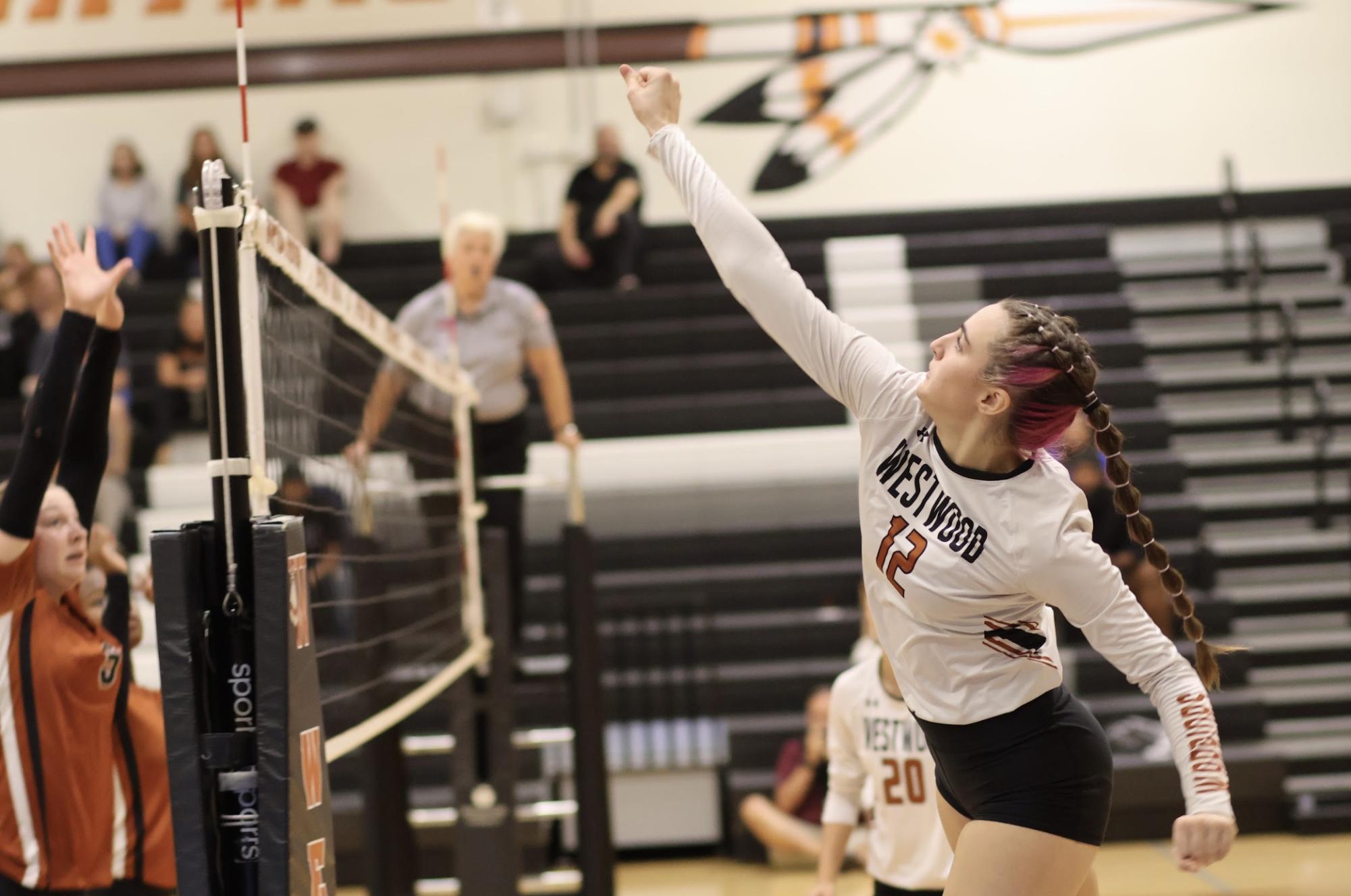 Following through after delivering a powerful punch to the ball, Outside Hitter Iris Huddleston '28 leaps into the air. Huddleston played a pivotal role in ensuring both Warrior defense and offense remained strong throughout the game. 